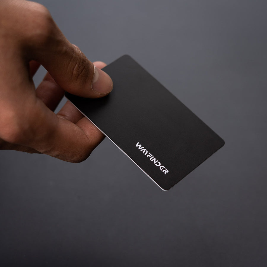 GLITCH RFID Data Blocking Card held in hand on dark gray background